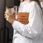 Brown faux leather journal with "Funny Things My Students Said" engraved on the cover, closed with an elastic band.