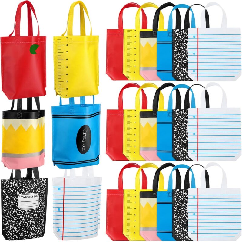 A set of 24 colorful non-woven tote bags with various back-to-school designs like pencils, crayons, and apples.