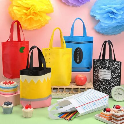 A set of 24 colorful non-woven tote bags with various back-to-school designs like pencils, crayons, and apples.