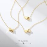 Close-up of a Turandoss 18K gold plated heart initial necklace with a letter A pendant on a white background.